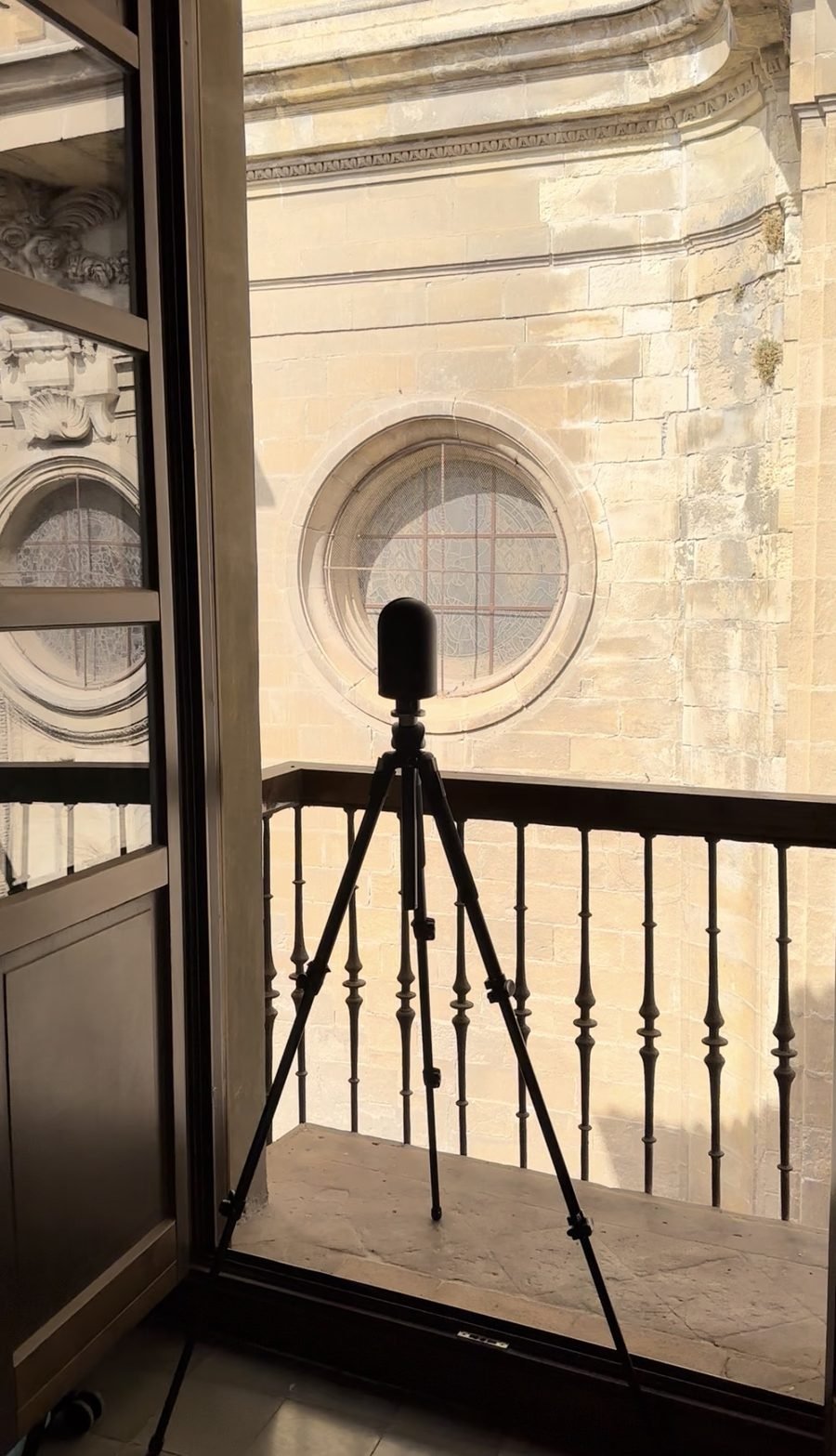 LiDAR scanner positioned to capture a carved stone rose window on a cathedral façade