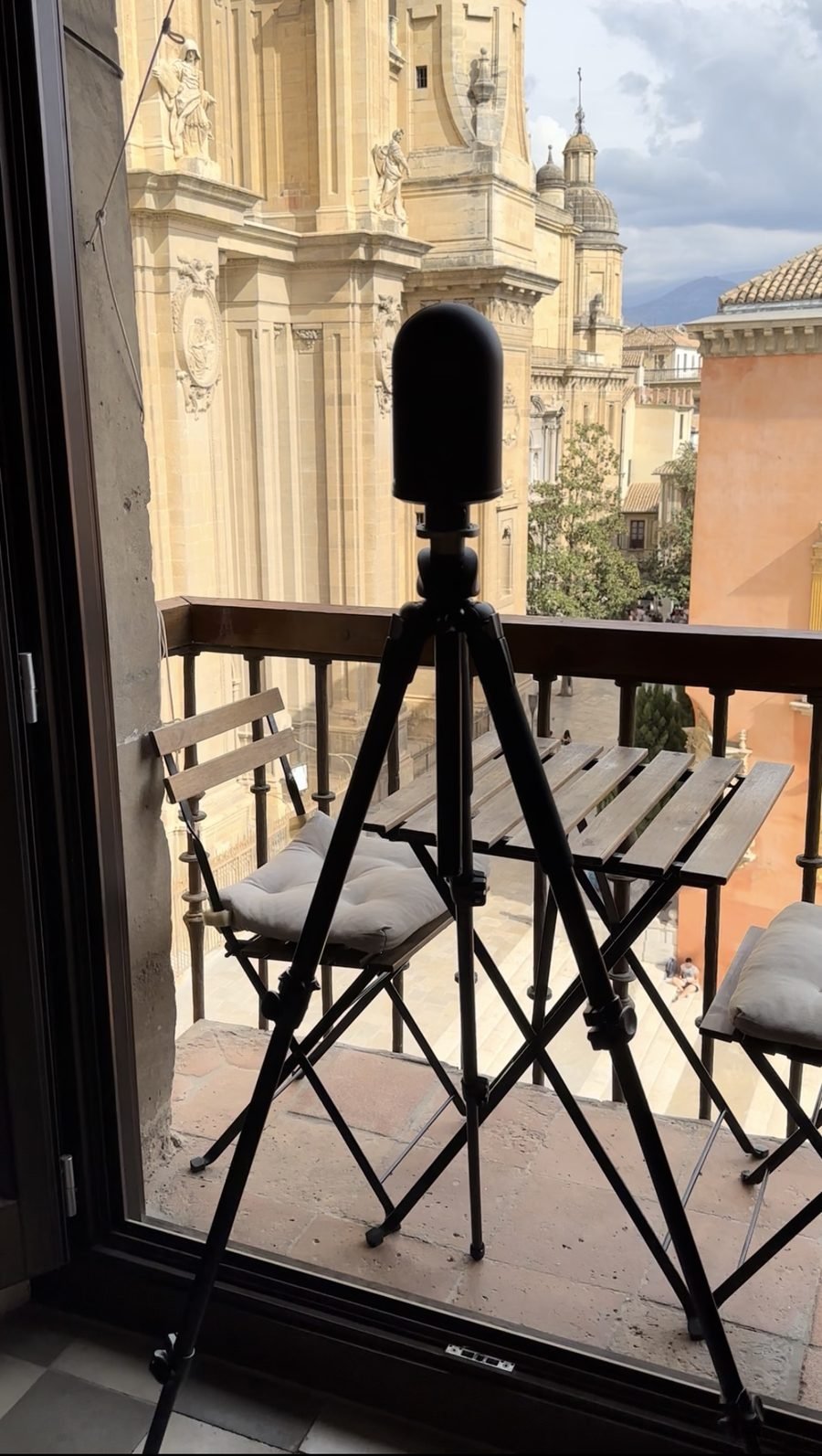 Tripod-mounted LiDAR scanner set up on a balcony facing the Renaissance and Baroque towers of a historic cathedral